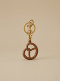 Pretzel bag charm keychain with brown enamel metal pretzel charm, gold snap hook, and split ring