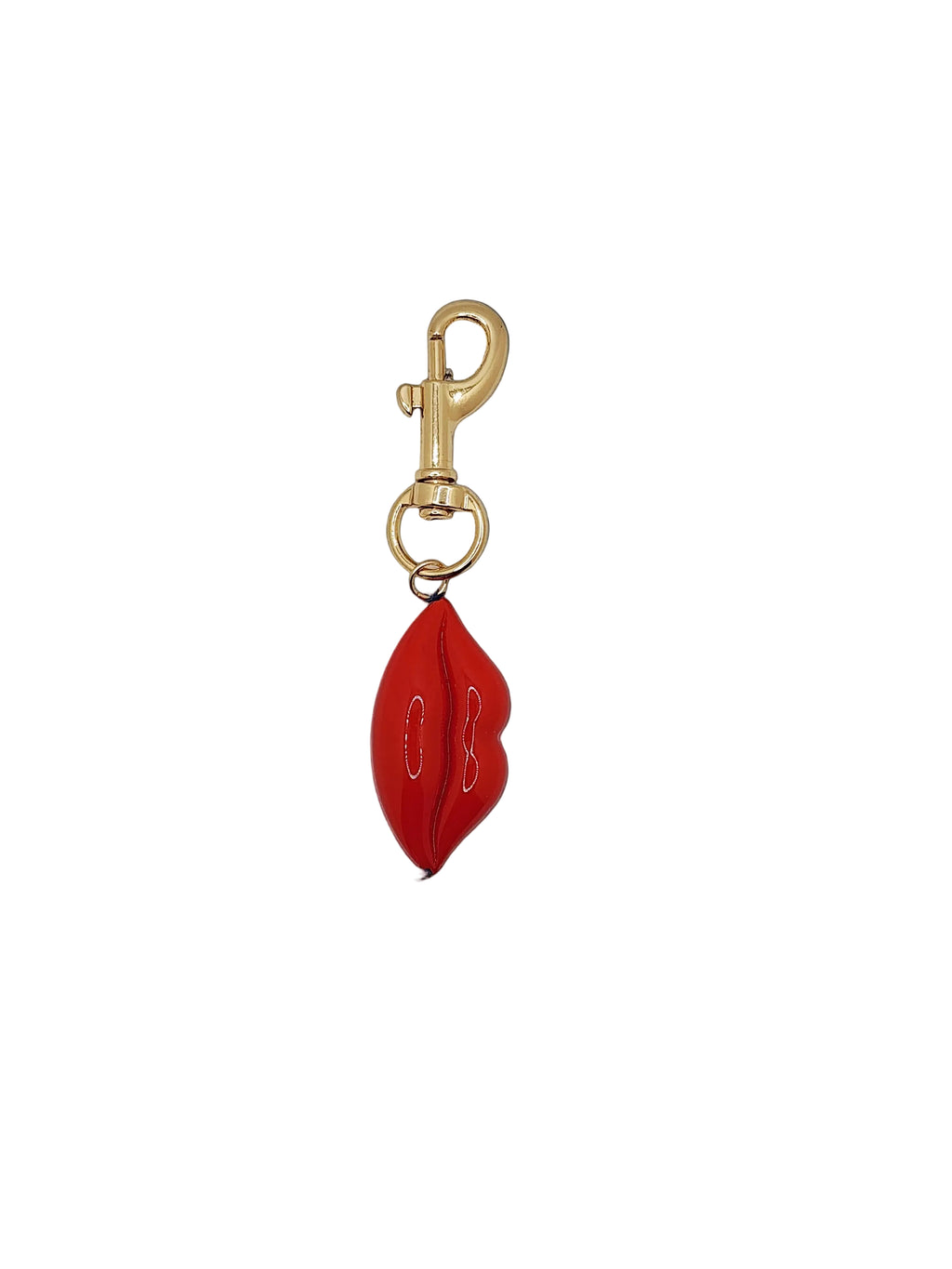 Red lip-shaped keychain with gold clasp on a black background