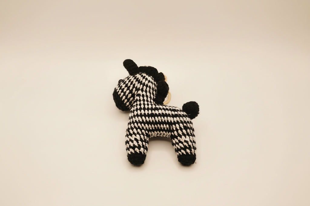 Black and white knitted toy on a light gray background