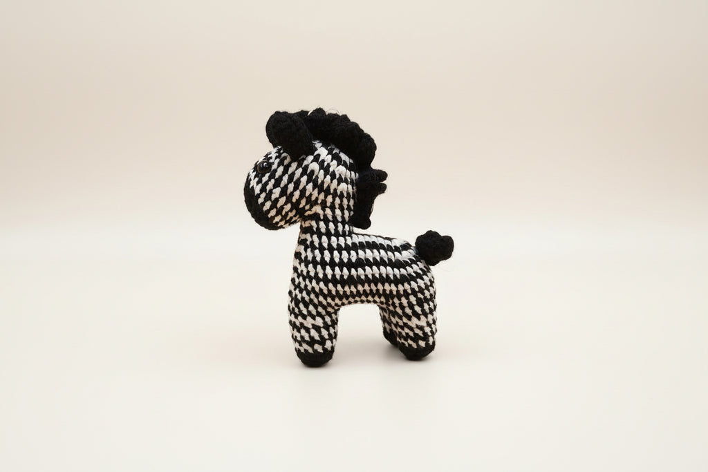Black and white checkered dog toy on a light gray background
