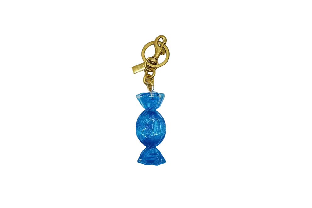 Blue candy-shaped keychain with gold chain on a light gray background