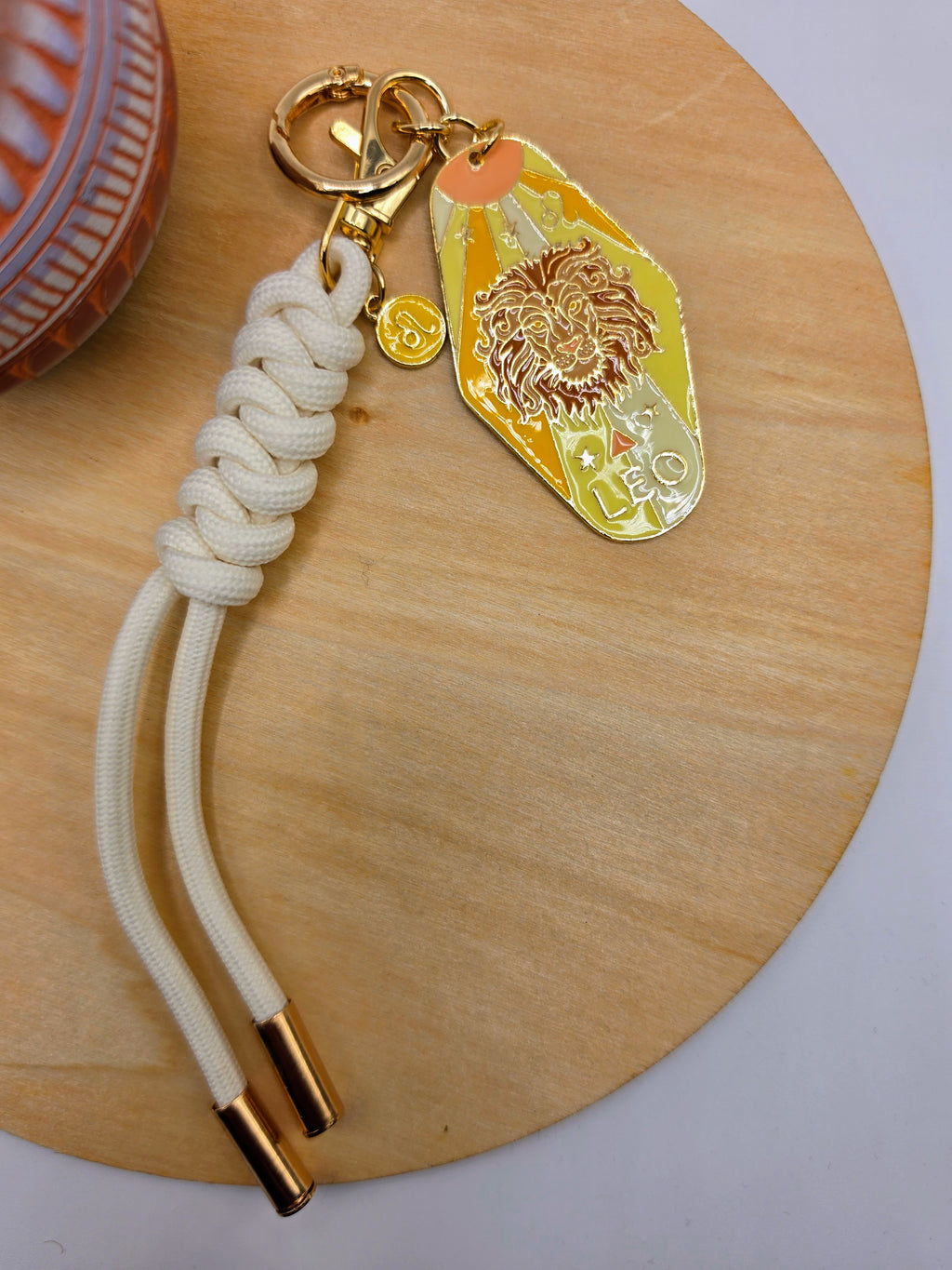 Keychain with rope and zodiac sign tag on a wooden surface