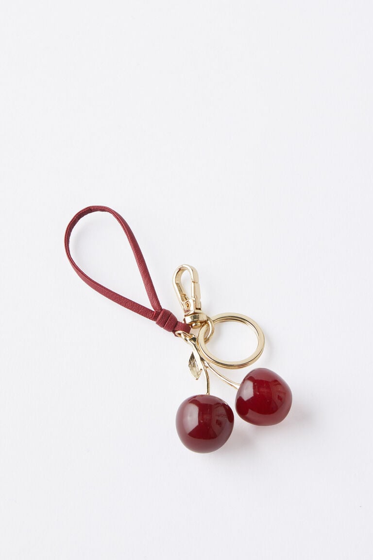 The Cherry On Top high-gloss bag charm with red glitter cherries, gold-tone hardware, leaf detail, strap, and clasp