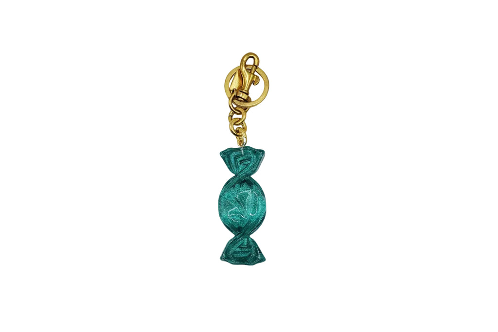 Teal candy-shaped keychain with gold clasp on a white background