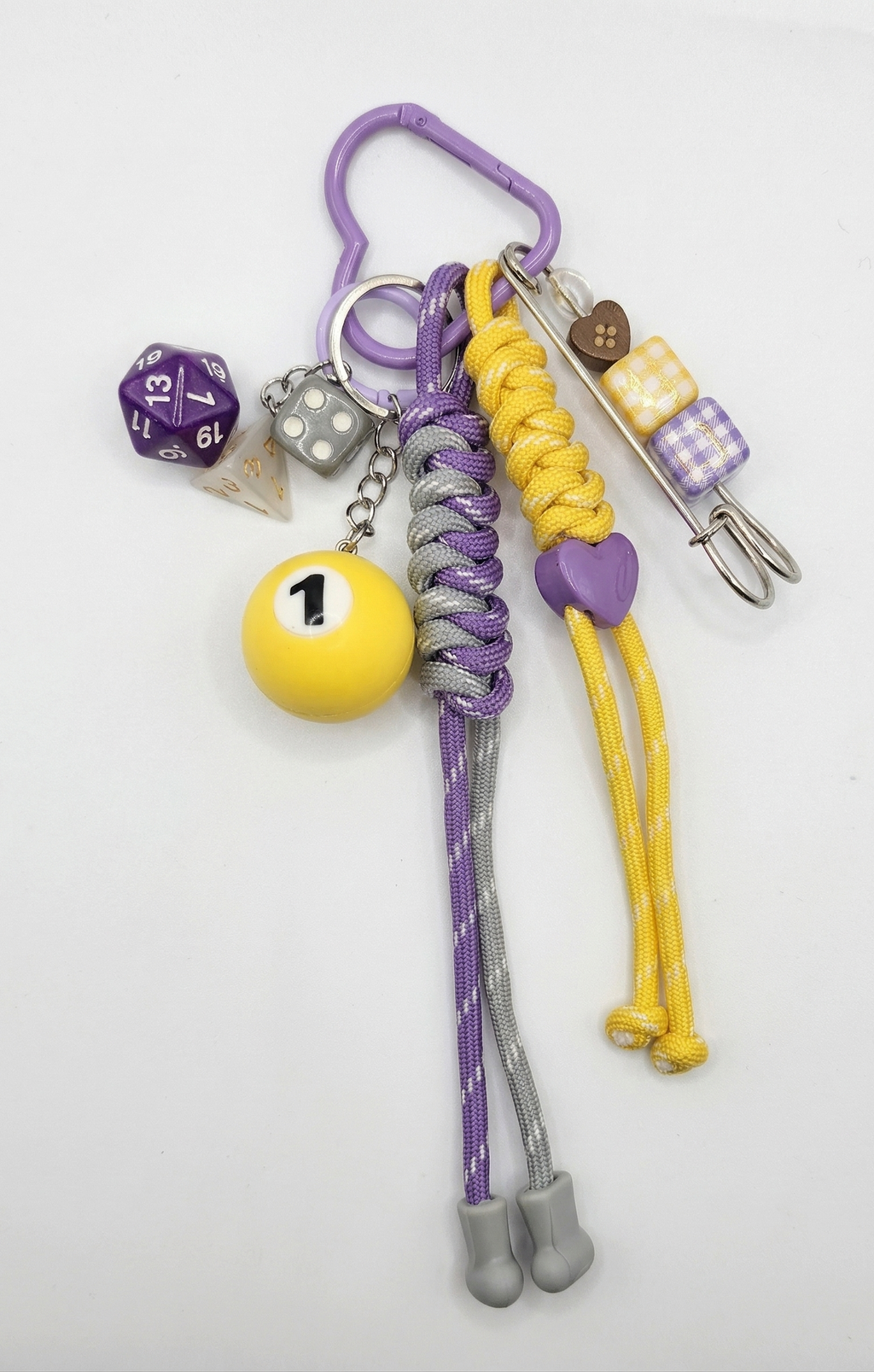 Keychain with various charms including a dice, billiard ball, and colorful beads on a white background