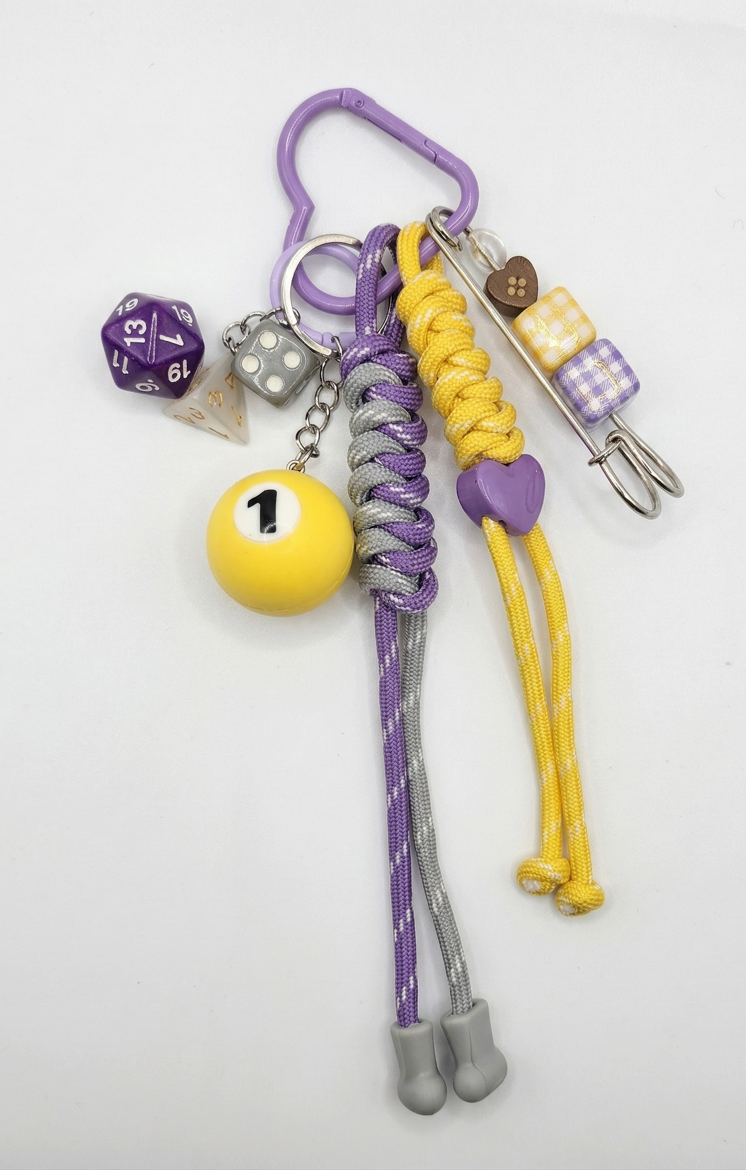Keychain with various charms including a dice, billiard ball, and colorful beads on a white background