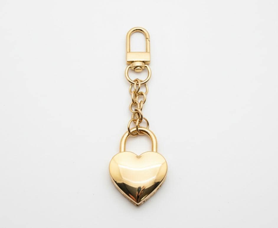 Gold heart-shaped padlock keychain on a light gray background