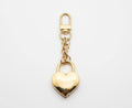 Gold heart-shaped padlock keychain on a light gray background