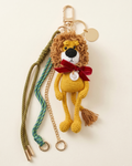 The King of the Forest custom lion bag charm with 5-inch crochet lion, red bow, crown, engraved gold pendant, and cords