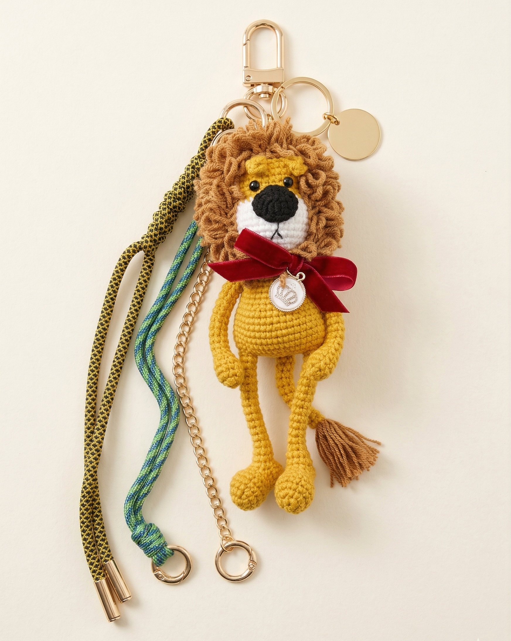The King of the Forest custom lion bag charm with 5-inch crochet lion, red bow, crown, engraved gold pendant, and cords